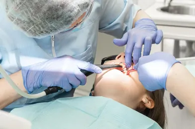 A dentist performing a root canal on a patient.